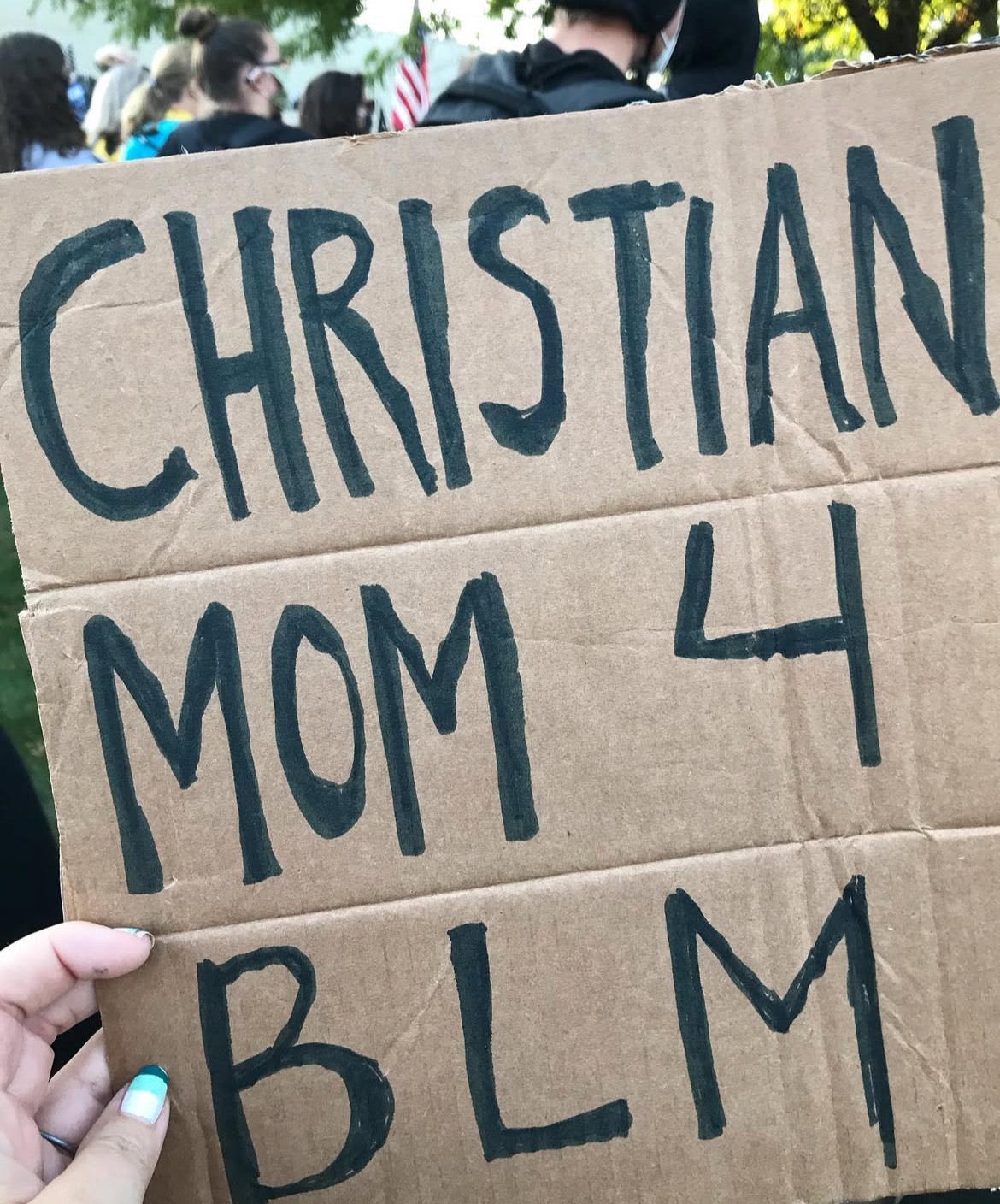 image of a cardboard sign that says Christian moms for BLM