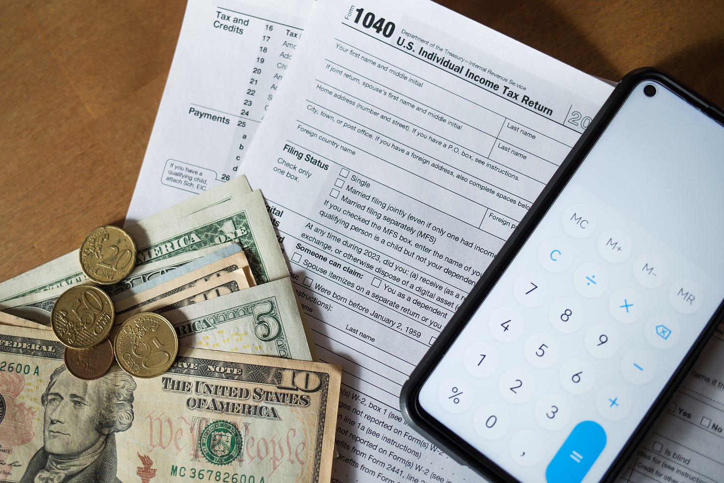 U.S. 1040 tax form with calculator and cash — symbolizing real estate agent tax preparation.