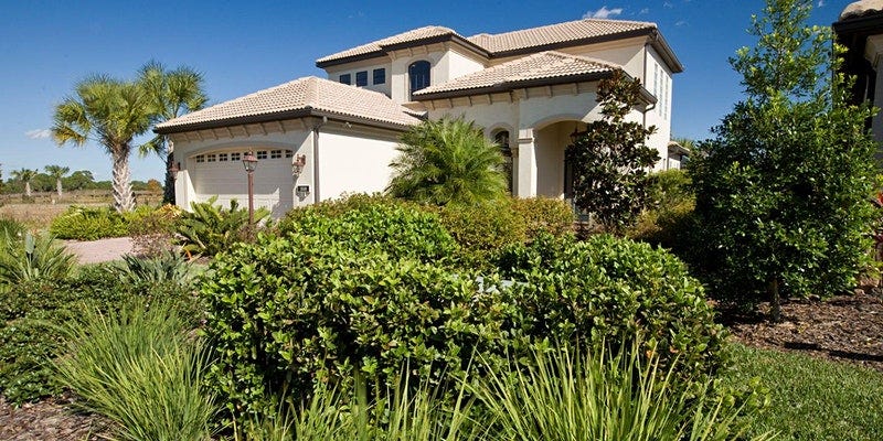 a two story home with a well landscaped lawn