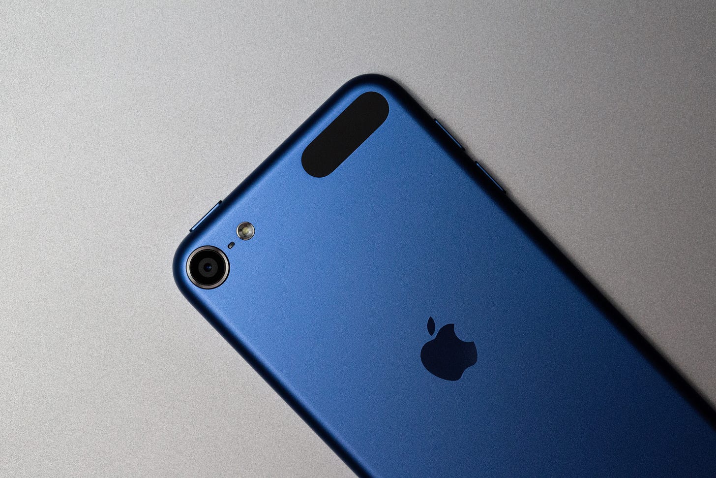A photograph of the back of a blue Apple iPhone