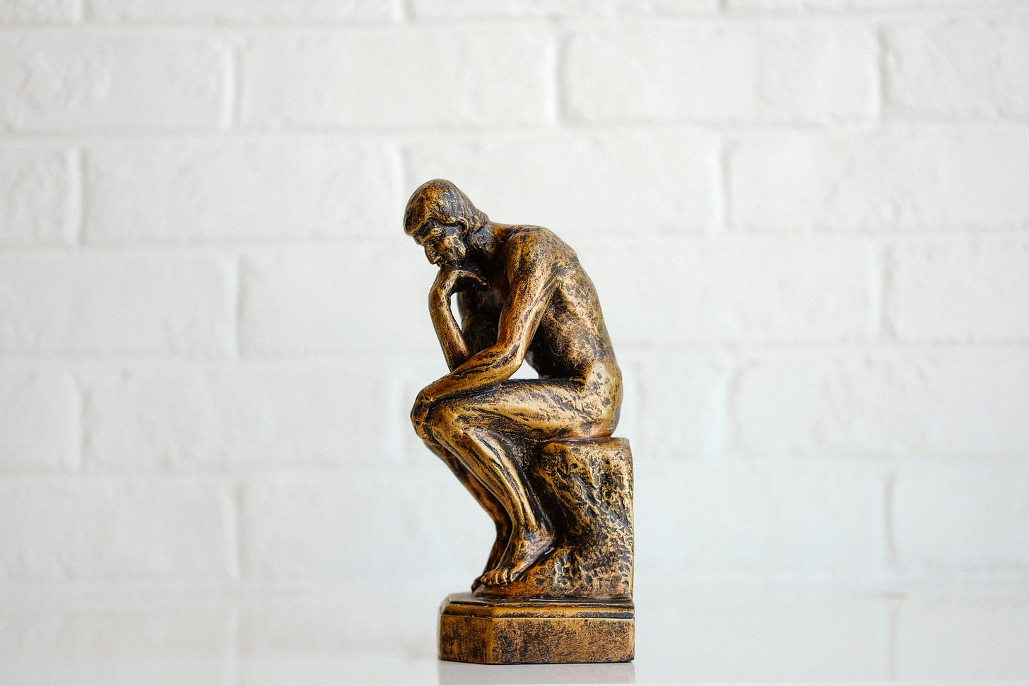 bronze transformed into a person sitting statue taking a pose of thinking