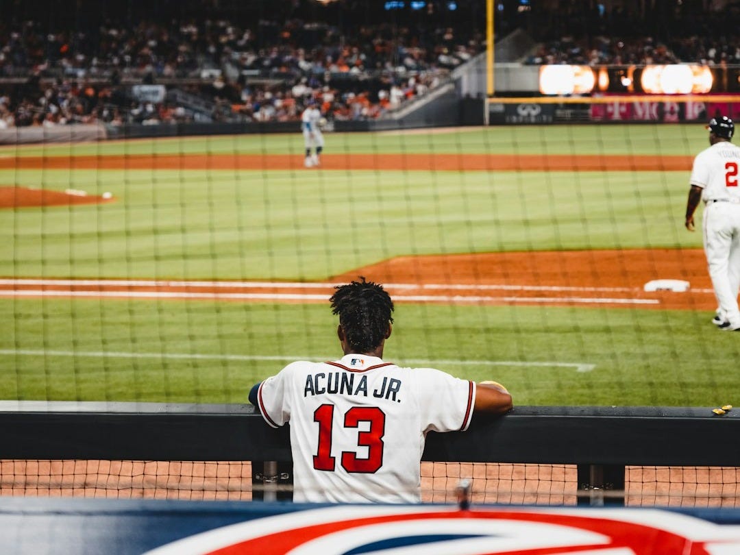 man in white jersey shirt playing baseball