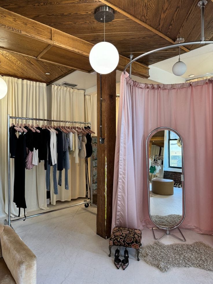 This may contain: an open closet with clothes hanging on hangers and a large mirror in the middle This may contain: an open closet with clothes hanging on hangers and a large mirror in the middle
