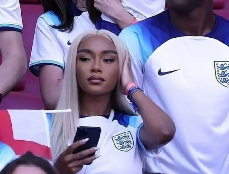 This may contain: a group of people sitting next to each other at a soccer game