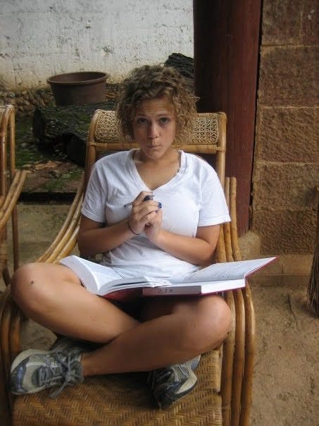 Young Caroline sitting outdoors writing in a journal with a dictionary Young Caroline sitting outdoors writing in a journal with a dictionary