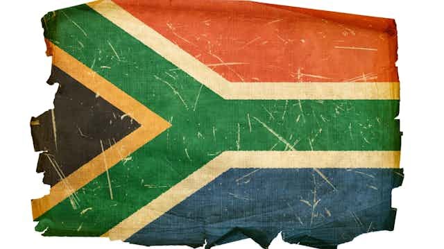 Tattered flag in red, white, green, blue, black and yellow