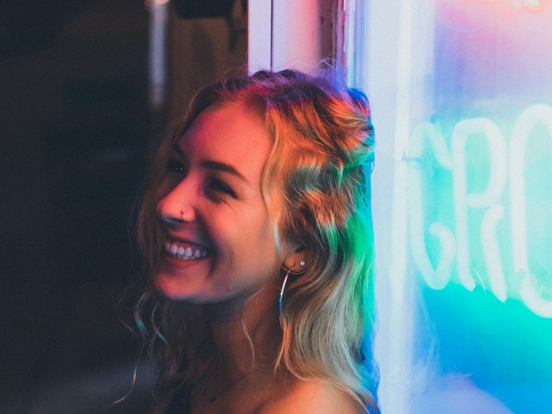 woman leaning on neon signage