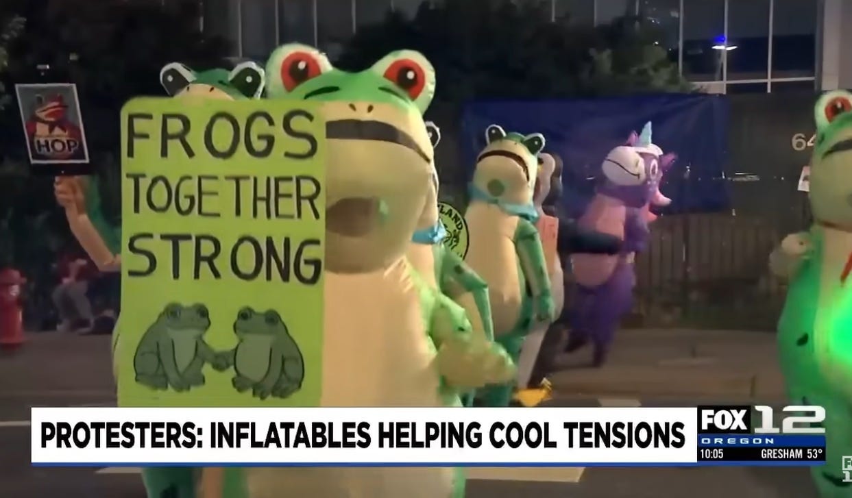 A parade of people in inflatable frog costumes, with one purple unicorn bringing up the rear. Lead frog carries a sign reading 'Frogs together strong.' Another protester carries a sign parodying Obama's 'Hope' campaign poster, but with a frog and the caption 'HOP.' A parade of people in inflatable frog costumes, with one purple unicorn bringing up the rear. Lead frog carries a sign reading 'Frogs together strong.' Another protester carries a sign parodying Obama's 'Hope' campaign poster, but with a frog and the caption 'HOP.'