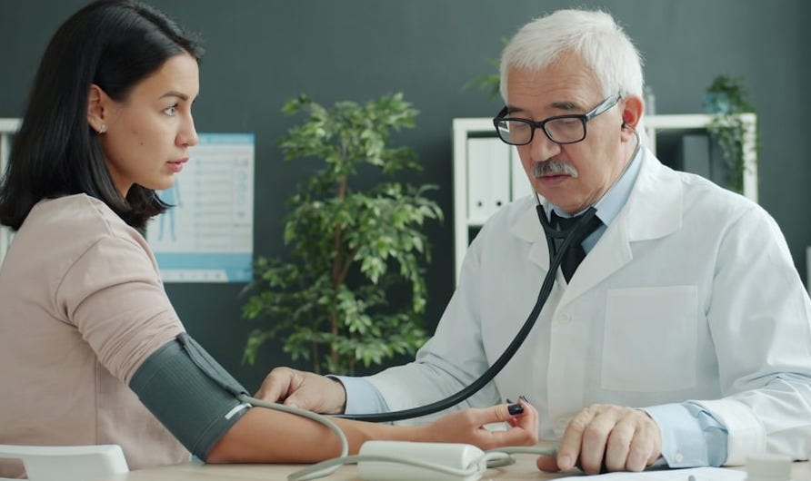 Doctor checks patient's blood pressure with stethoscope. Doctor checks patient's blood pressure with stethoscope.