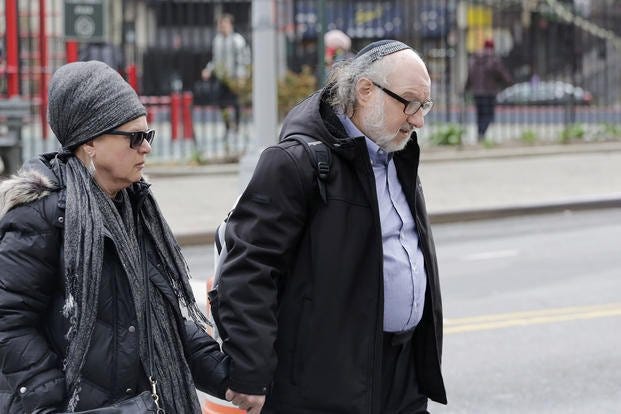 Convicted spy Jonathan Pollard enters federal court with his wife.