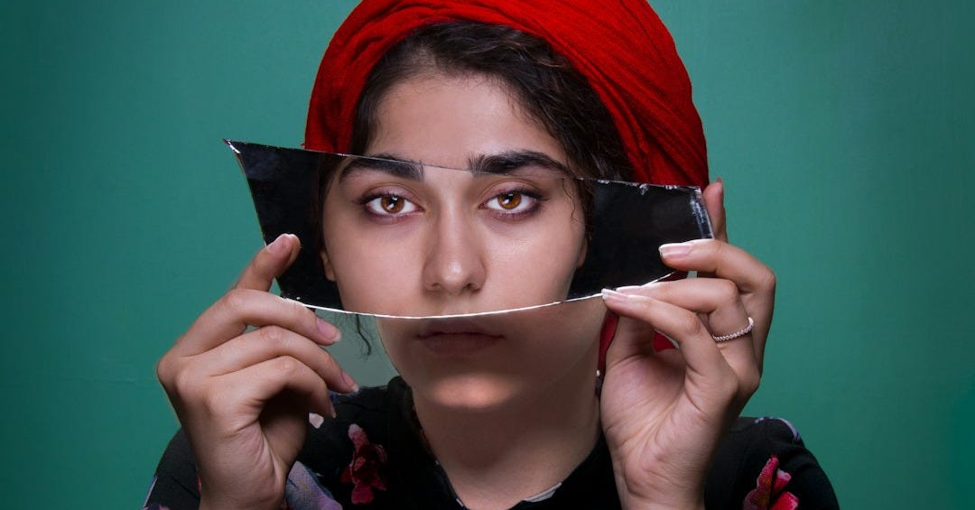 woman holding mirror shard woman holding mirror shard
