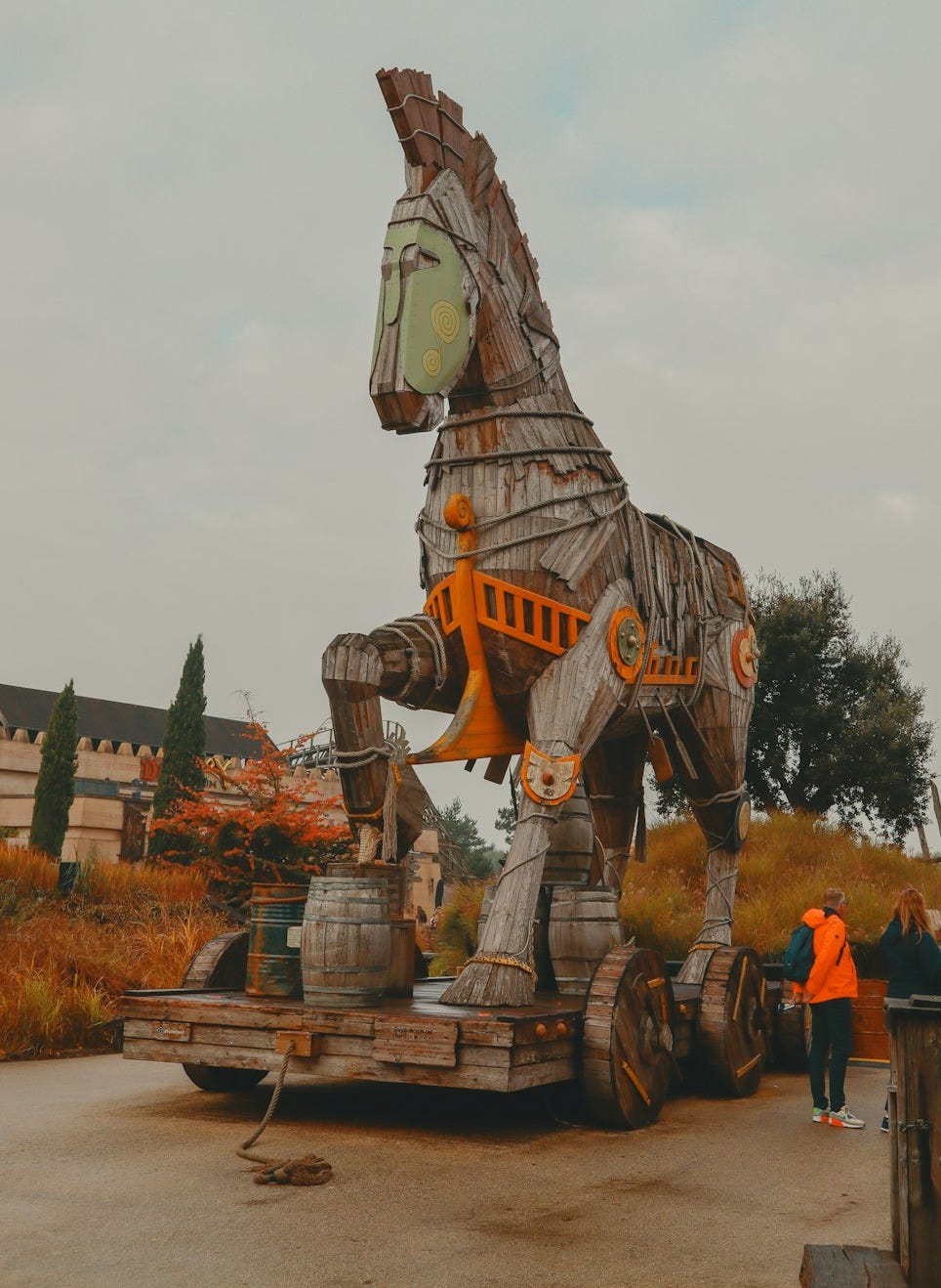 a large wooden horse statue sitting on top of a dirt field