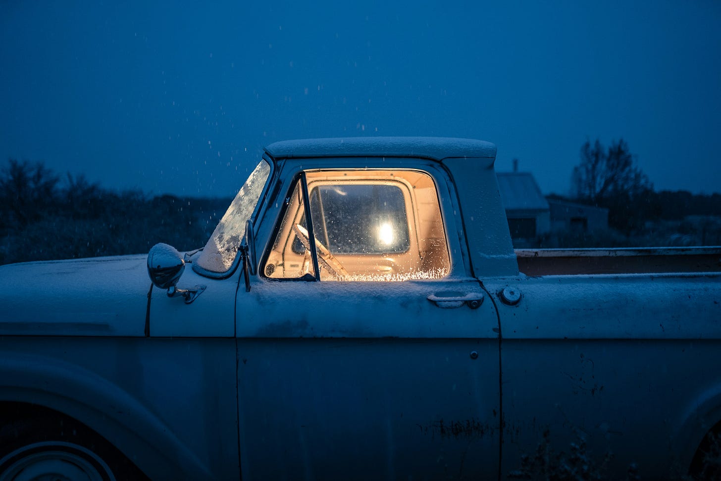 A white pickup truck with a light inside. 