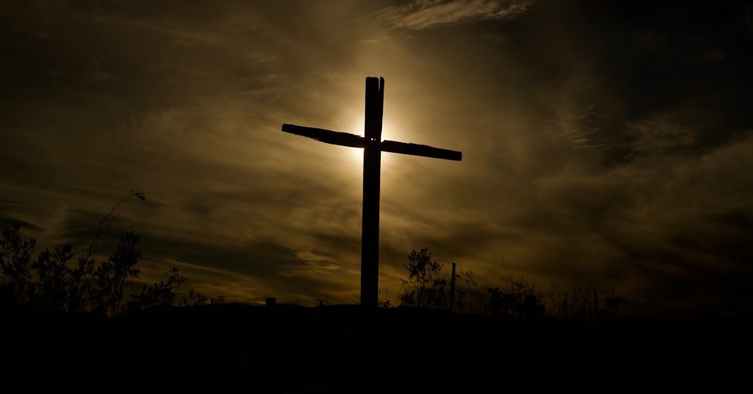 brown wooden cross under cloudy sky during daytime