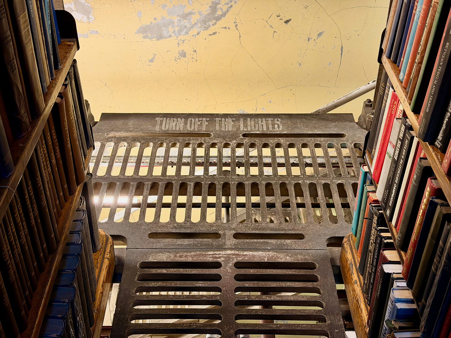 Library shelves. The words "Turn Off the Lights" are painted onto the metal floor Library shelves. The words "Turn Off the Lights" are painted onto the metal floor