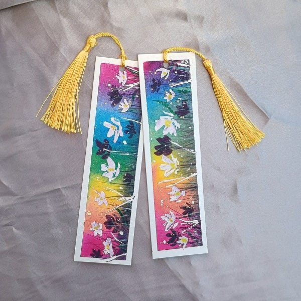 a pair of handpainted rainbow floral bookmarks