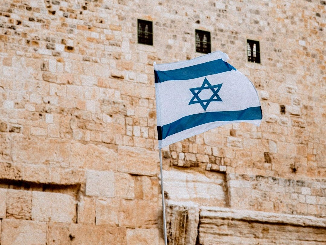 a flag flying in front of a stone building a flag flying in front of a stone building