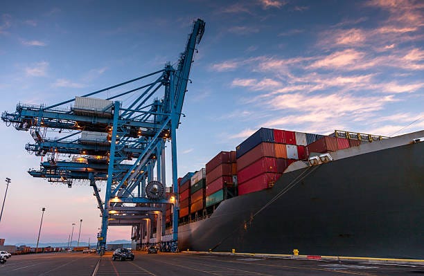 Still Image of Large Cargo Ship Parked on Container Terminal in Tacoma, Washington at Sunrise A still image of a cargo ship with numerous containers on Blair Waterway, parked on container terminal in the Port of Tacoma, Washington at sunrise. shipping containers stock pictures, royalty-free photos & images