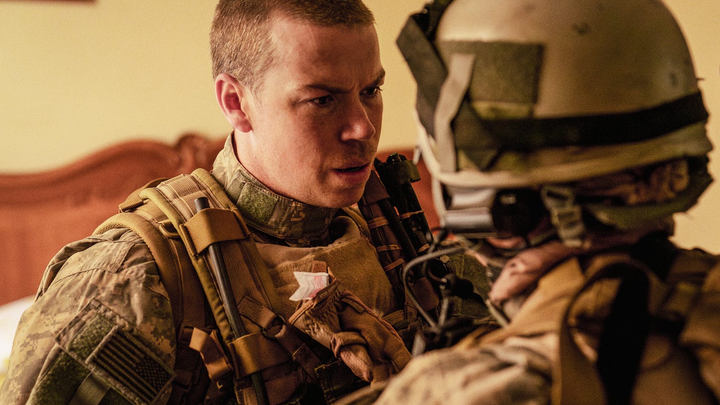 Will Poulter wearing a U.S. military uniform, talking to another soldier.