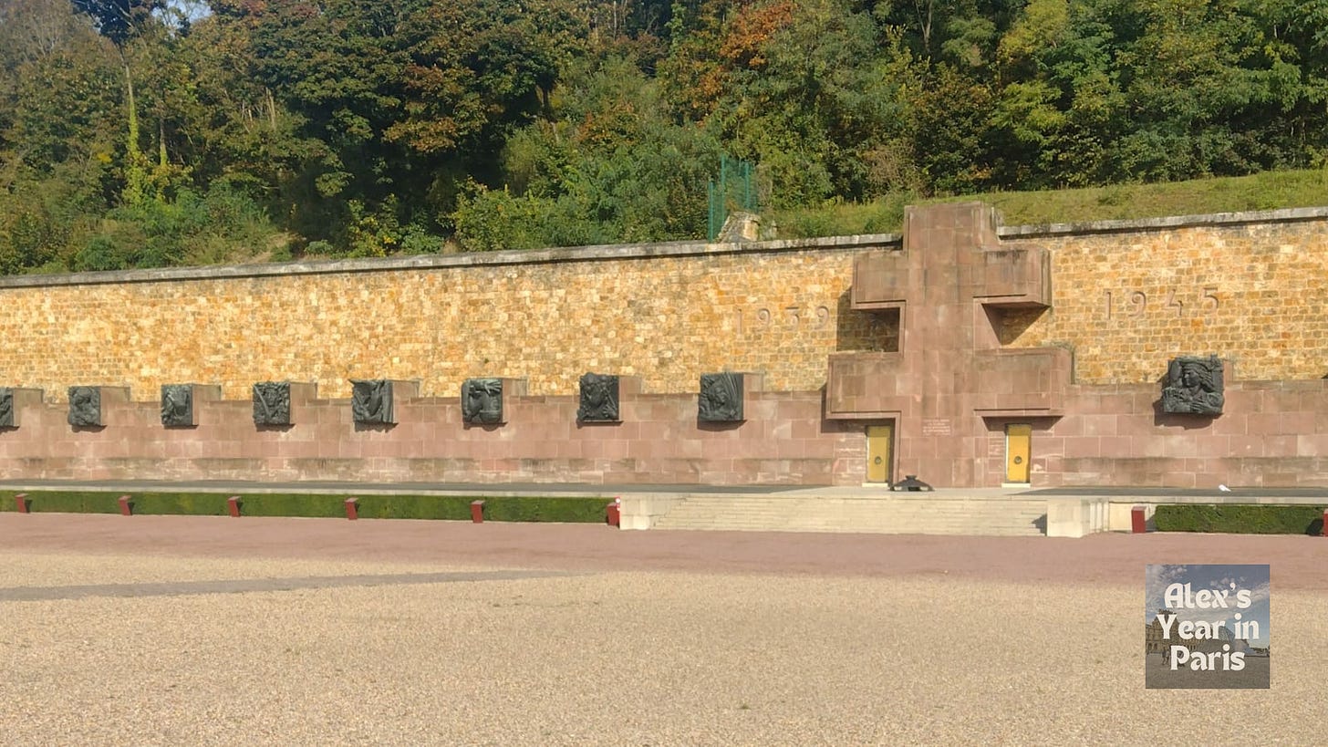 A wall embedded with sculptures and symbols forms the boundary of the military base