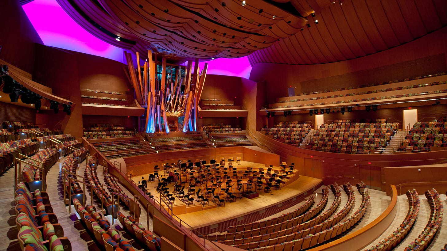 Large brown and orange concert hall with a three-story pipe organ in the center-rear of the stage Large brown and orange concert hall with a three-story pipe organ in the center-rear of the stage