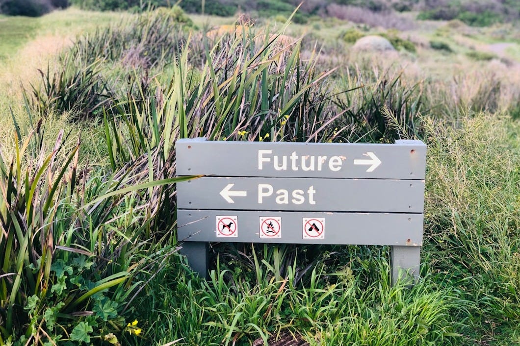 a sign in the middle of a grassy field