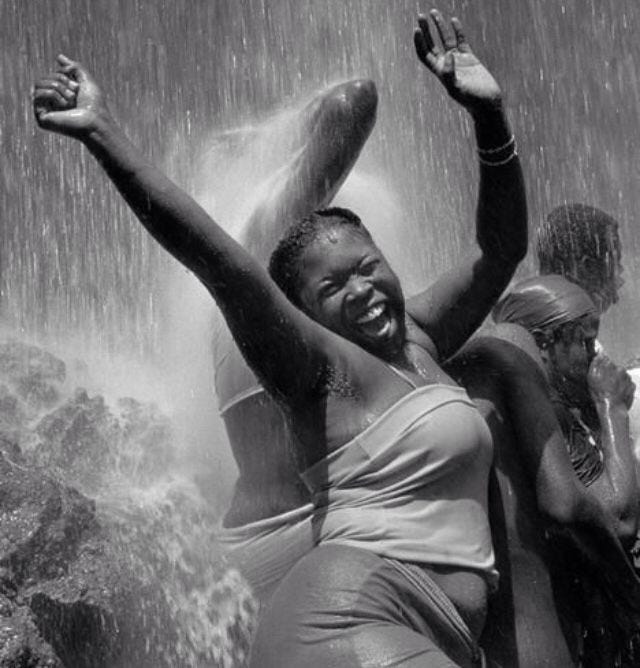 black women jubilantly dancing in the rain