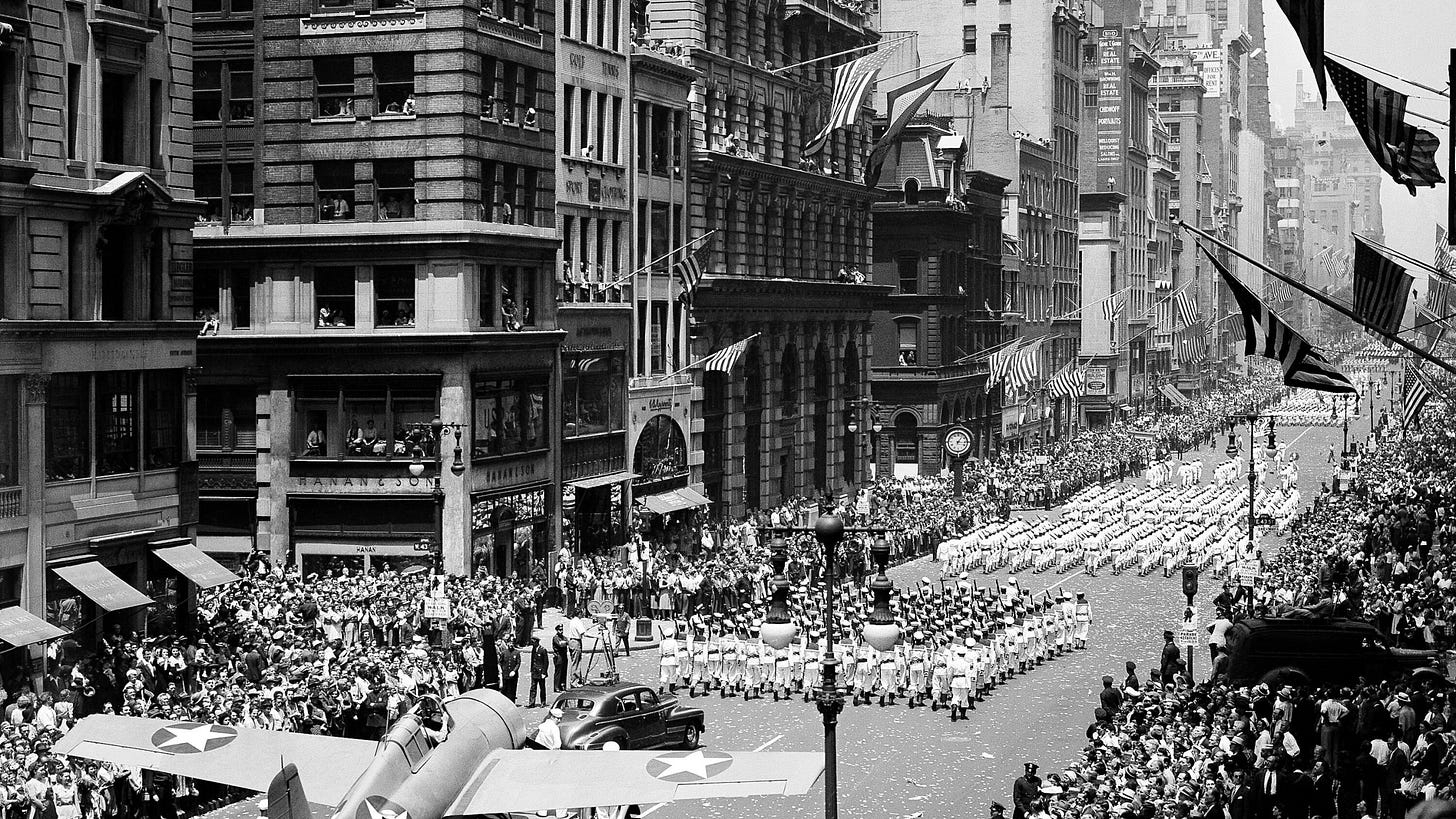FILE - Thousand of people line streets to cheer on naval units marching on Fifth Avenue in a war parade in New York, June 13, 1942. At lower left is a Grumman "Wildcat" fighter that is flown from U.S. aircraft carriers. (AP Photo, File)