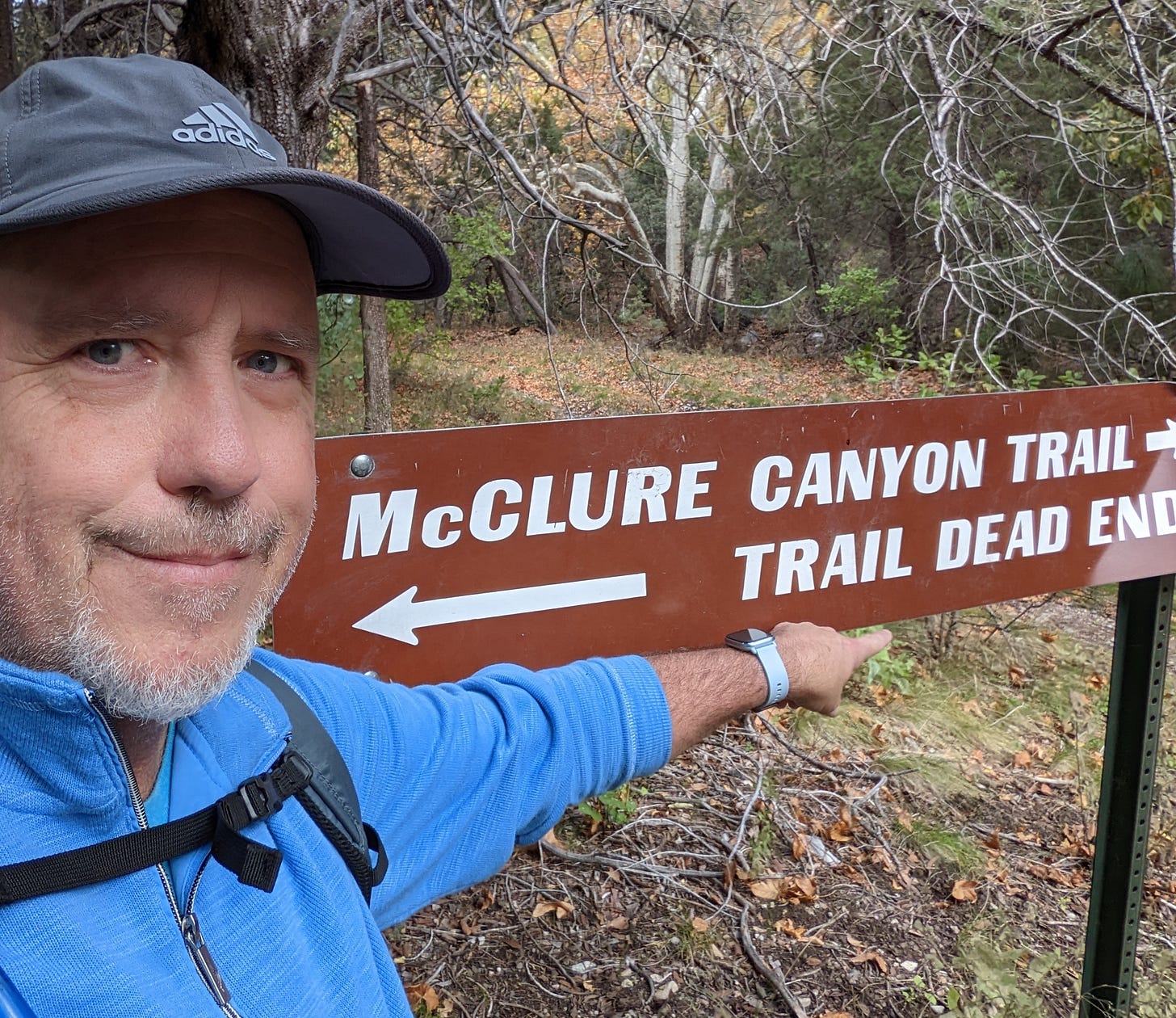 Todd standing next to a sign for McClure Canyon and a "Dead End" trail