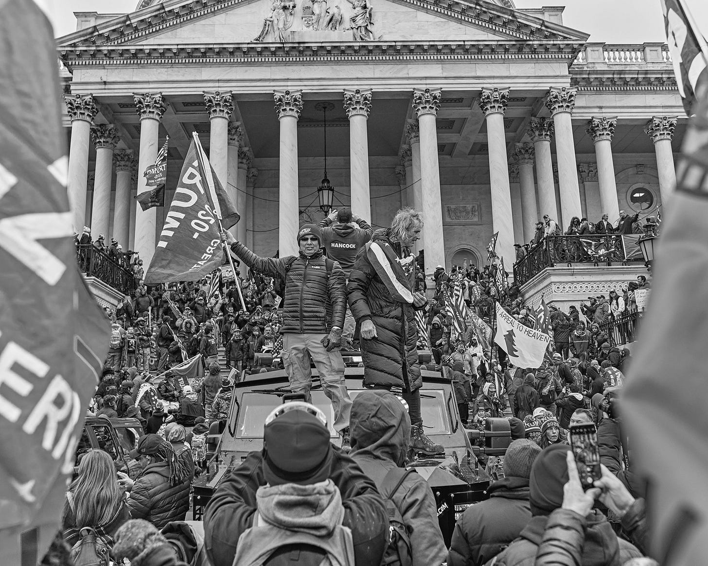 A blackandwhite photo of a crowd in front of a building in Washington D.C. on January 6 2021.