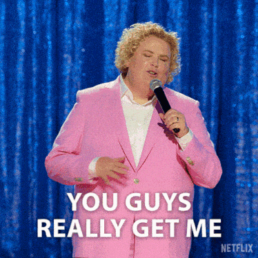 a man in a pink suit is holding a microphone and saying you guys really get me a man in a pink suit is holding a microphone and saying you guys really get me