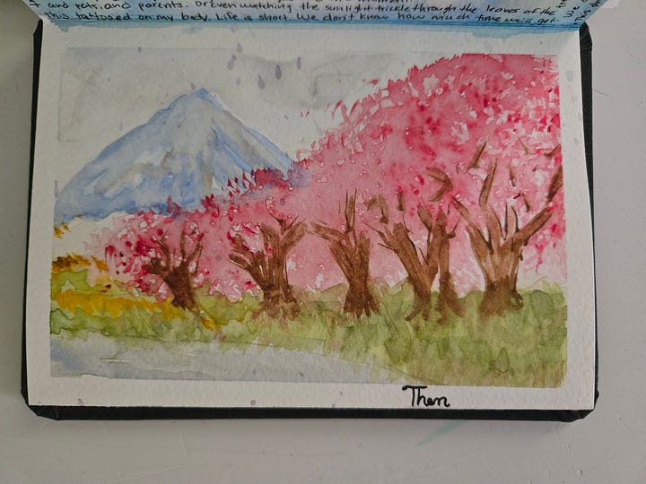 Watercolor sketchbook spread of Mount Fuji and cherry blossoms, paired with Japanese calligraphy and practice sketches inspired by Japan.