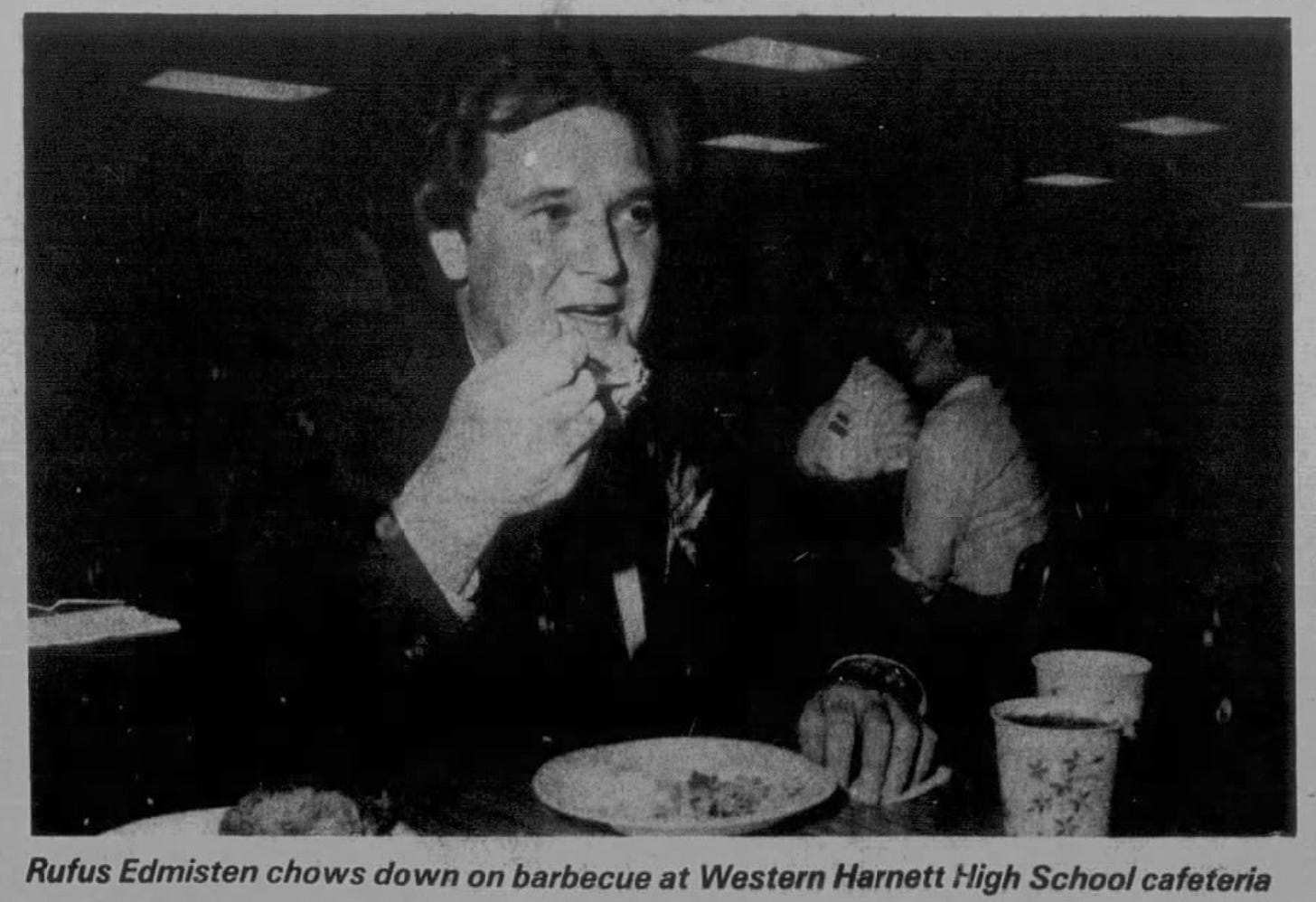 Pic of guy eating barbecue with caption: "Rufus Edmisten chows down on barbecue at Western Harnett High School cafeteria." Pic of guy eating barbecue with caption: "Rufus Edmisten chows down on barbecue at Western Harnett High School cafeteria."