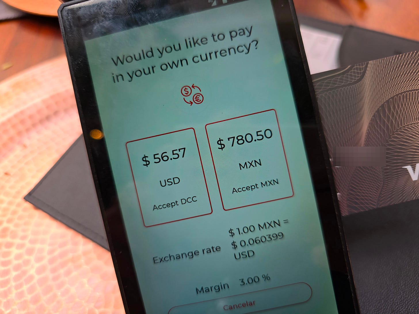 credit card payment terminal showing dollars and pesos