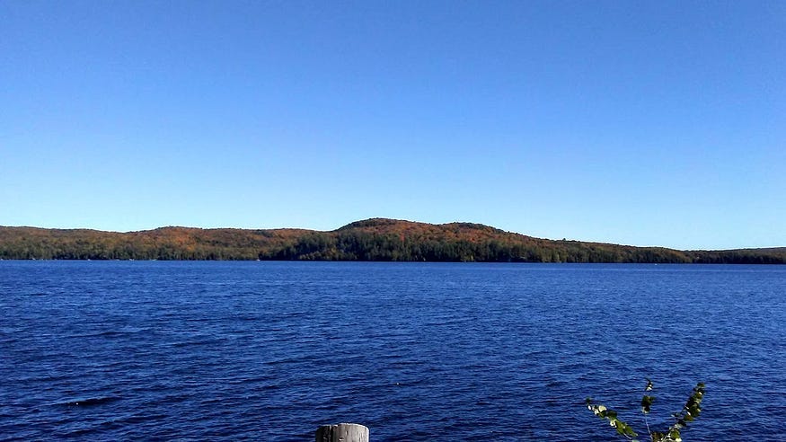 The far shore of Elephant Lake is a wooded hill. The lake and sky are a glorious deep blue.
