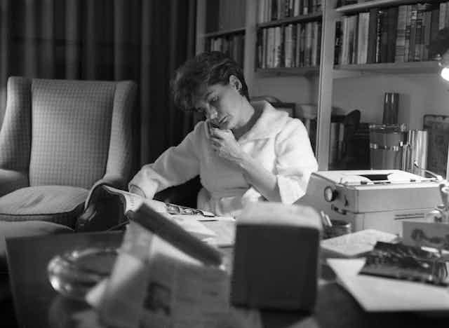 Black and white photo of a young woman on the phone, sitting at her desk. Black and white photo of a young woman on the phone, sitting at her desk.