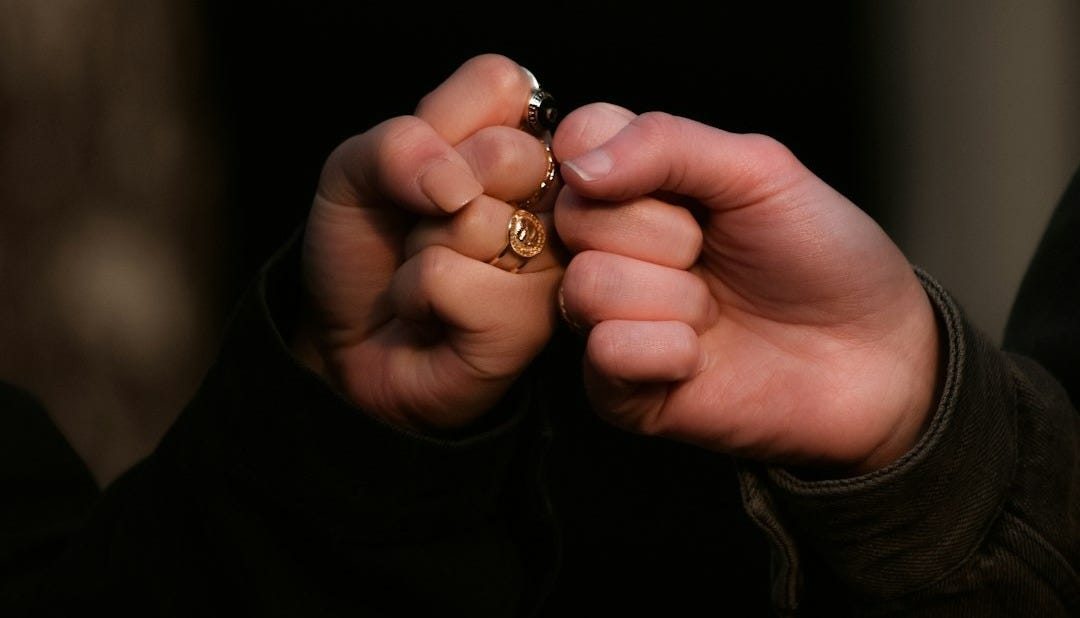 person holding gold ring in dark room person holding gold ring in dark room