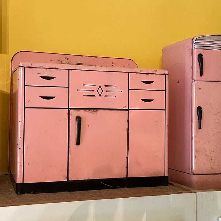 pink tin sink, sideboard, washing machine, and refrigerator in child sizes