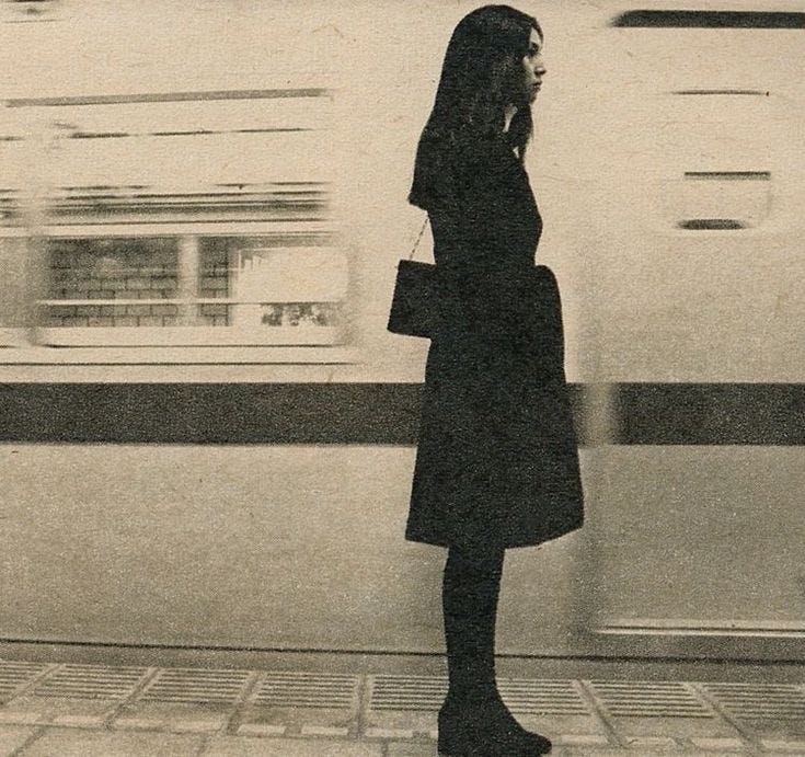 This may contain: a woman standing in front of a train