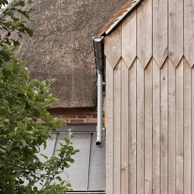 This may contain: a wooden building with a thatched roof