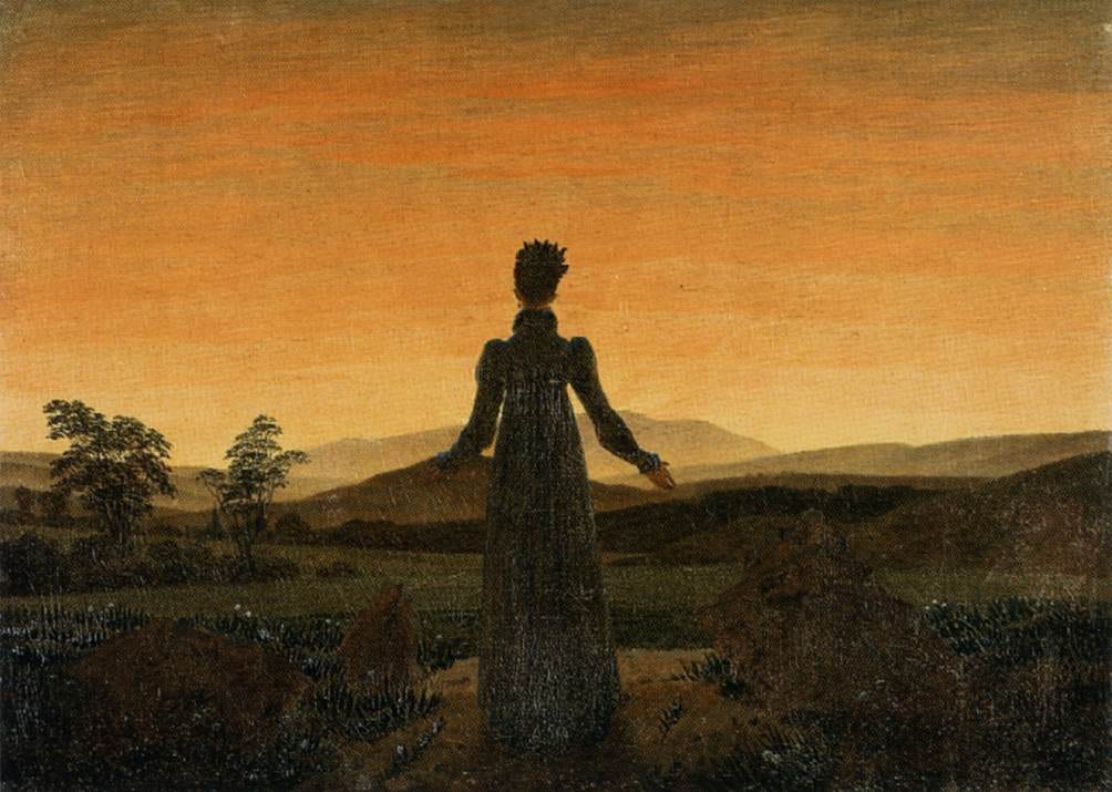 A woman stands with her back to us, arms slightly open, before a low glowing sunrise A woman stands with her back to us, arms slightly open, before a low glowing sunrise