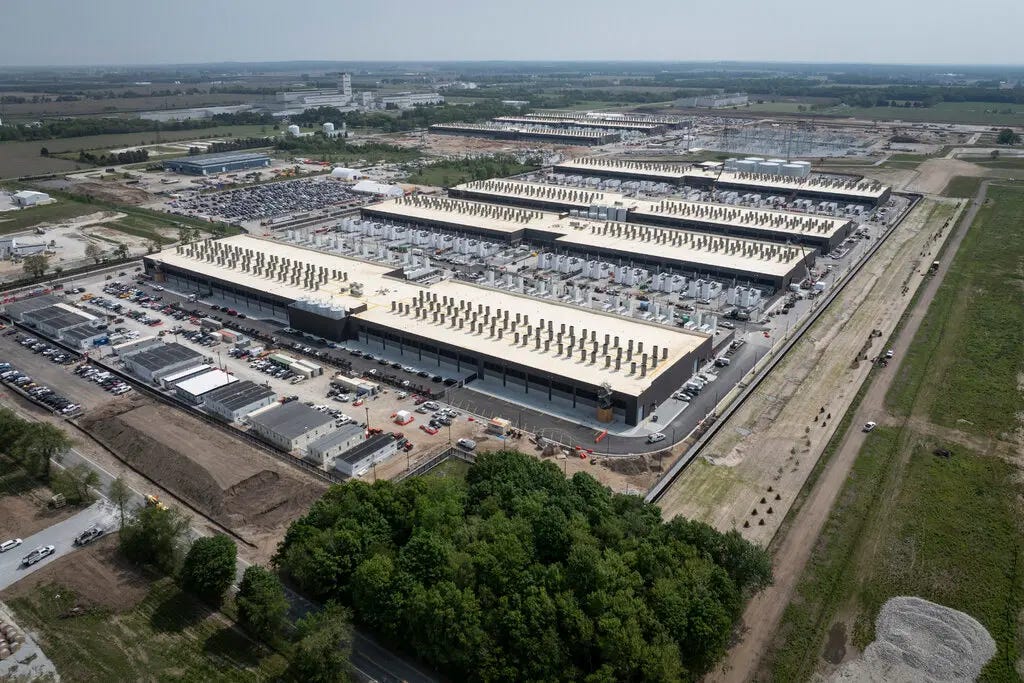 Giant buildings with white roofs are surrounded by farmland. Giant buildings with white roofs are surrounded by farmland.