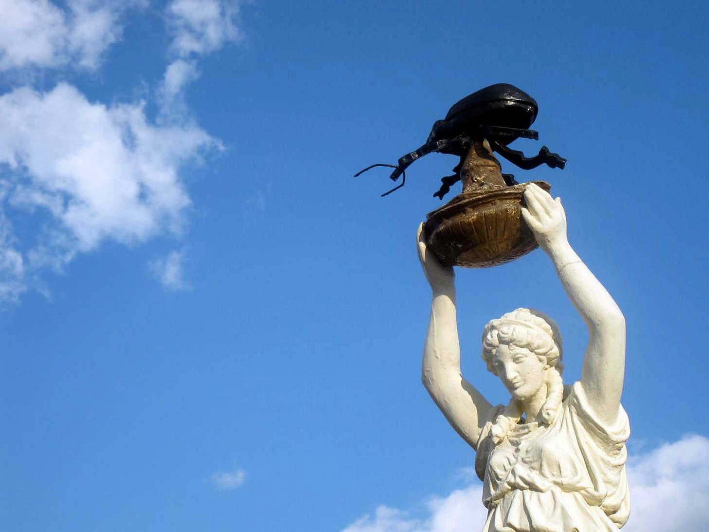 The monument consists of a woman holding a pedestal atop which there is a boll weevli insect - Provided by eccentricroadside.blogspot.com