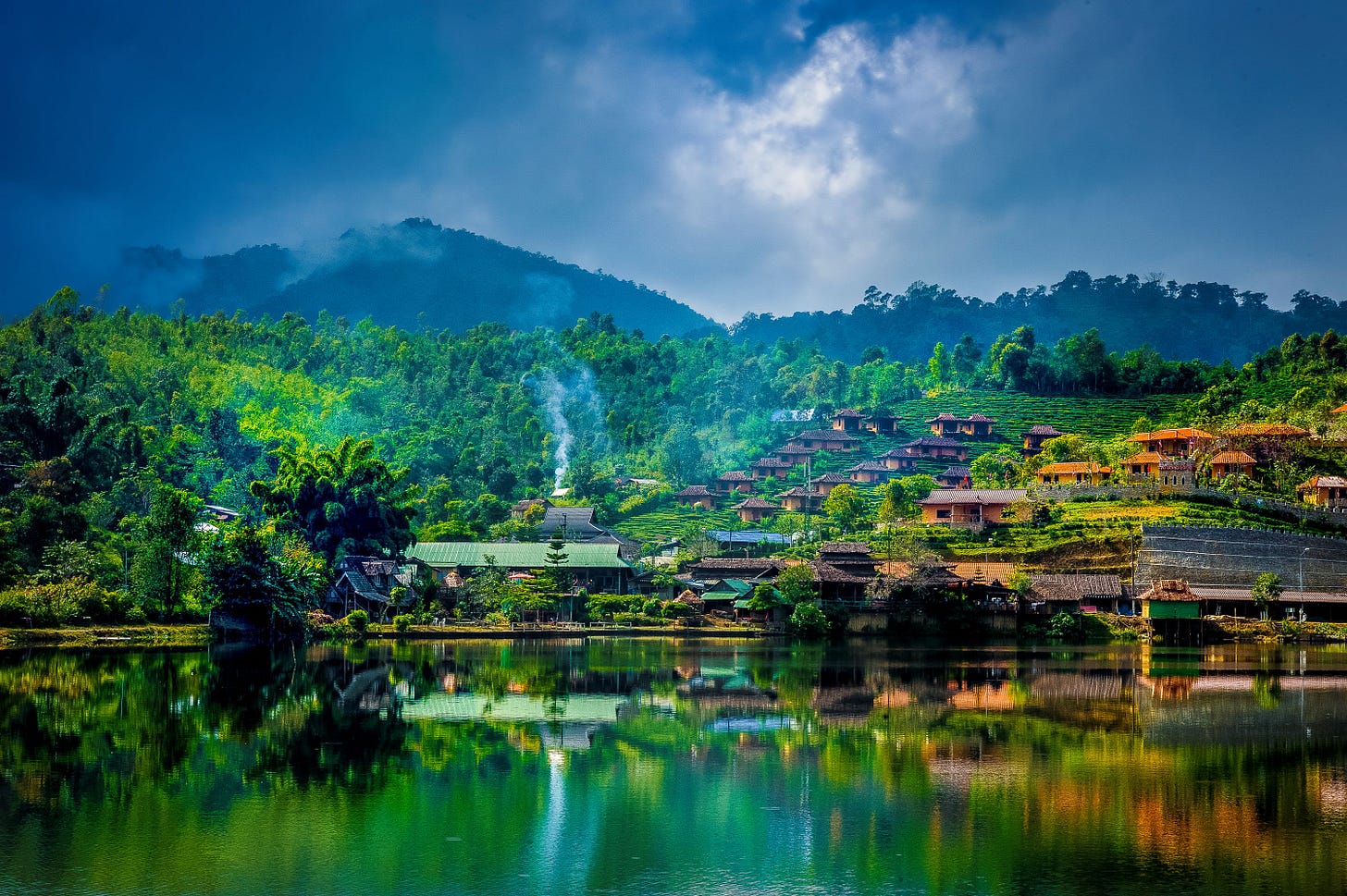 A mist-covered lake surrounded by mountains and tea plantations in Ban Rak Thai with its signature highland scenery. A mist-covered lake surrounded by mountains and tea plantations in Ban Rak Thai with its signature highland scenery.