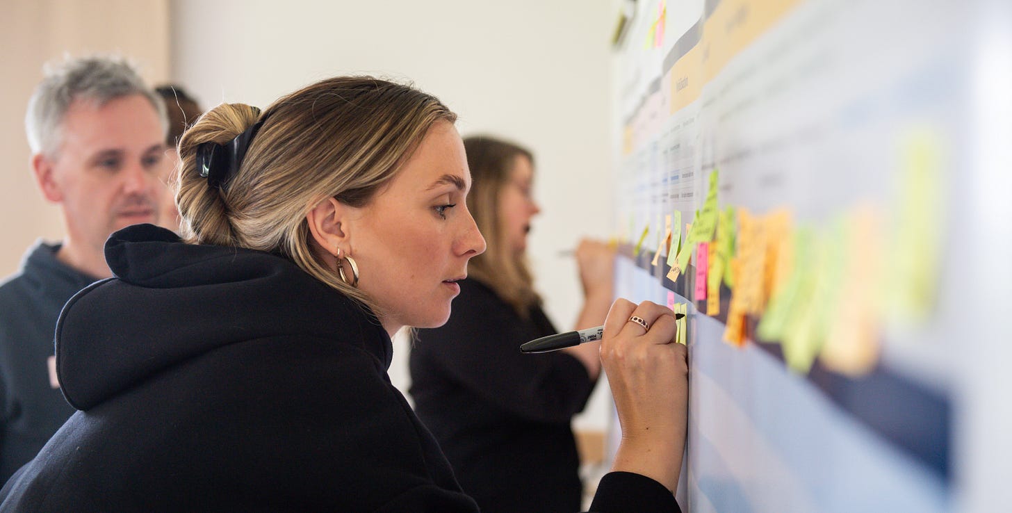 Nile Client Partner Robyn writes on a post-it note on a board