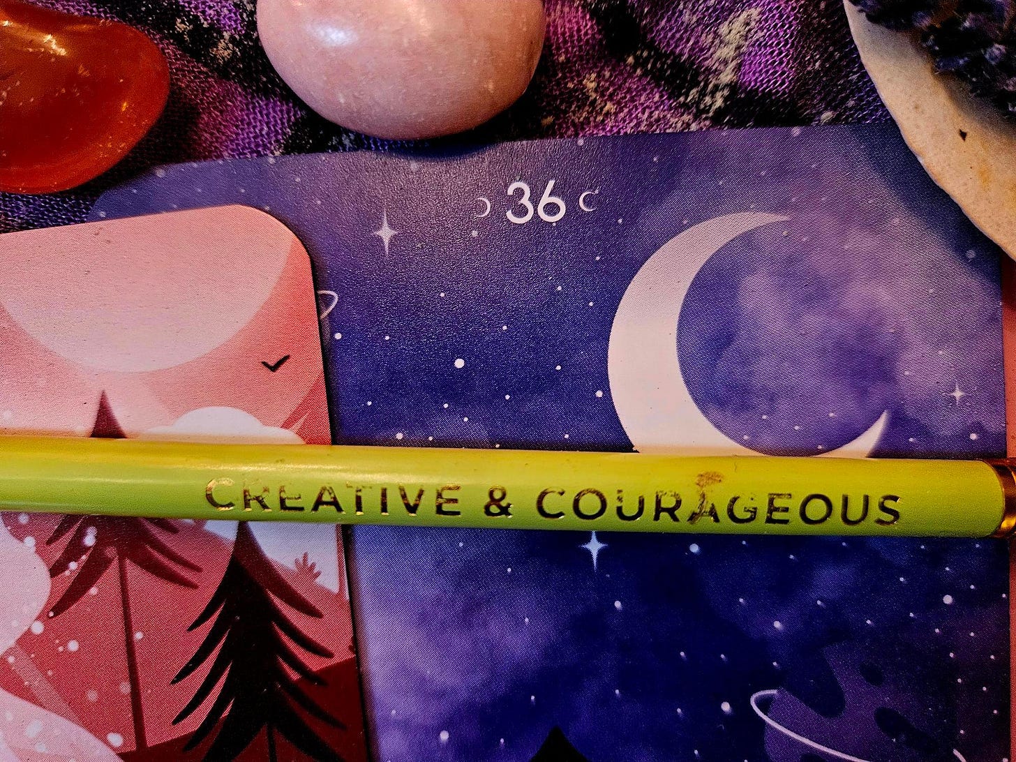 The yellow green “creative and courageous” pencil from my writing session in Emily Dickinson’s bedroom (Real Writing in the World #9) on a background of orange and purple oracle cards showing trees and a moon, and orange-red carnelian and pink Mangano calcite crystals. The yellow green “creative and courageous” pencil from my writing session in Emily Dickinson’s bedroom (Real Writing in the World #9) on a background of orange and purple oracle cards showing trees and a moon, and orange-red carnelian and pink Mangano calcite crystals.
