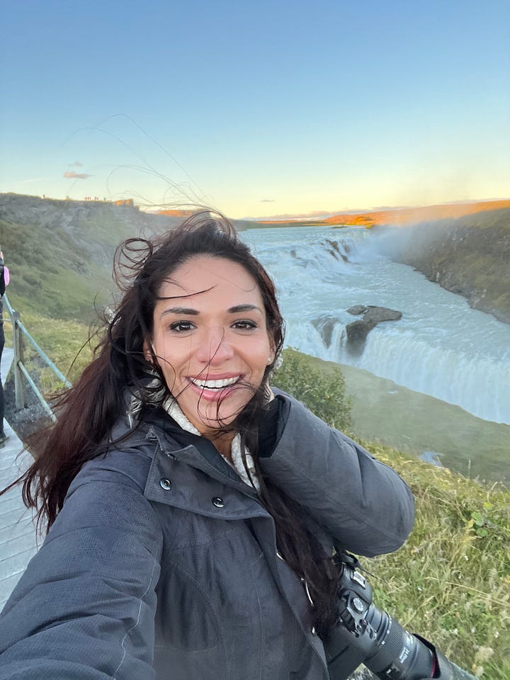 Counter-clockwise from top left: woman near base of the Seljalandsfoss waterfall as it pours into a small lake; selfie photo of woman near base of the Skogafoss waterfall, with a rainbow behind her and in front of the waterfall; selfie photo of woman from a view point with Fjadrargljufur canyon below and behind her; selfie photo of woman with strong winds blowing up from the Gullfoss waterfall behind and below her.
