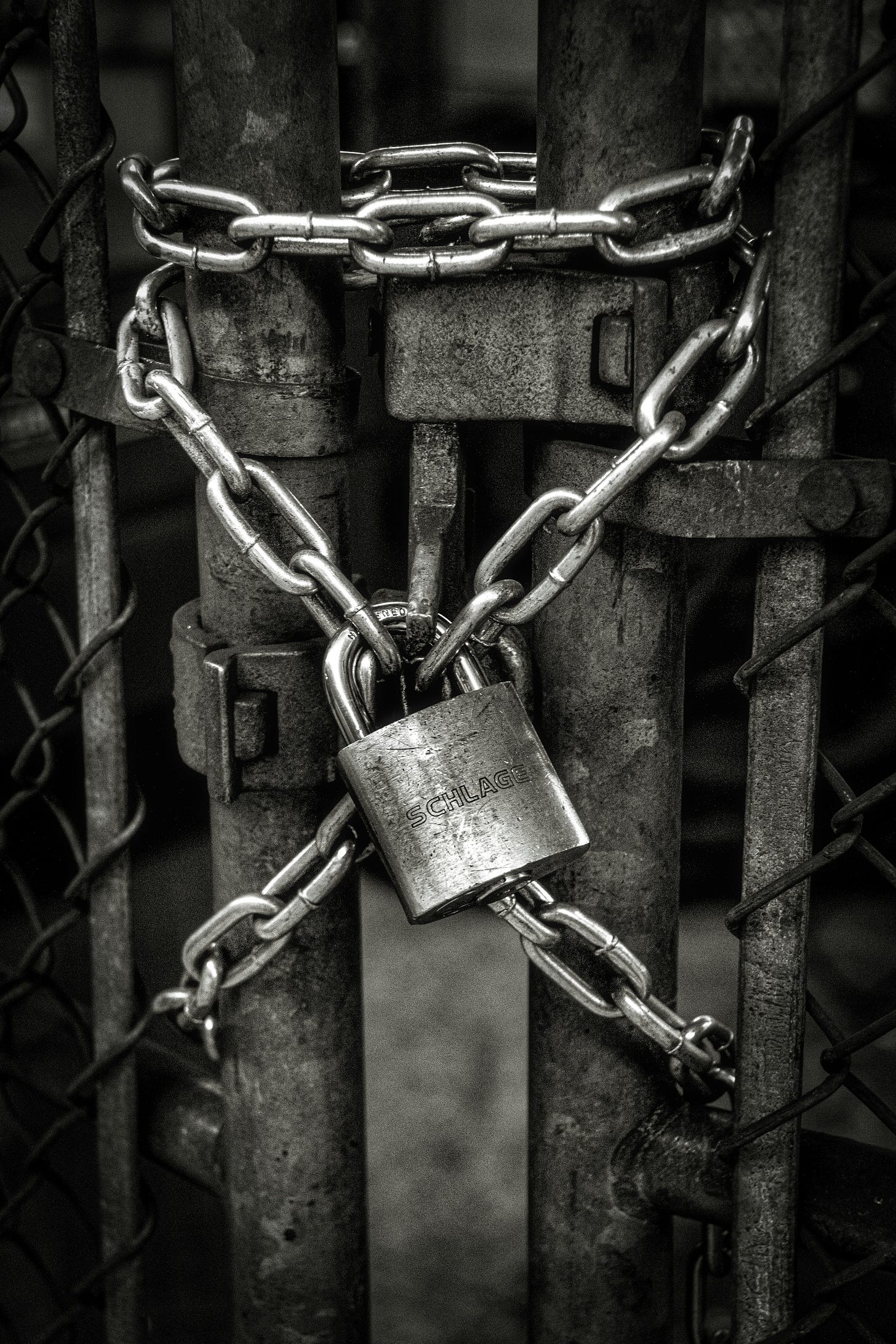A fence gate chained and locked with a padlock