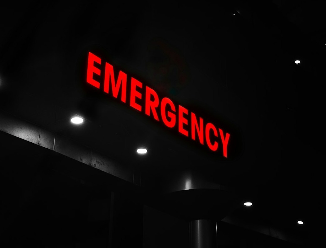 Red emergency sign illuminates a dark building entrance.