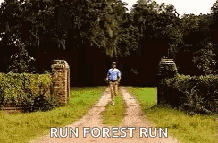 a man is running down a dirt road with the words run forest run on the bottom .
